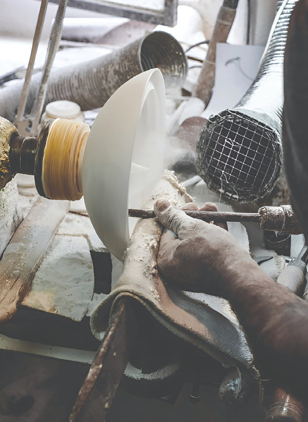 Craftsman shaping a metal shade in the workshop
